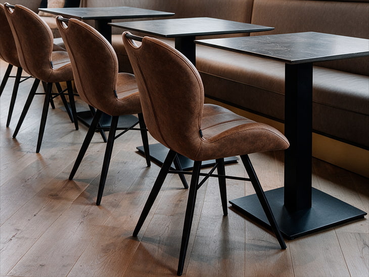 Table horeca à plateau en stratifié compact dressée dans une salle de restaurant