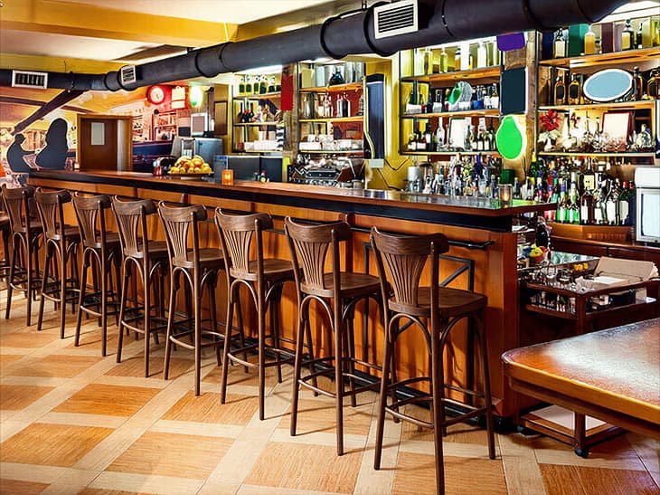 Tabourets de bar en bois alignés le long d'un comptoir de café