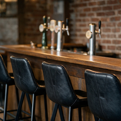 Chaises de bar en métal et simili cuir le long du comptoir d’un café liégeois